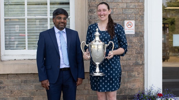 Corrigan holding the Frank May Cup, photographed with the President and Vice-Chancellor of the University of Leicester, Nishan Canagarajah