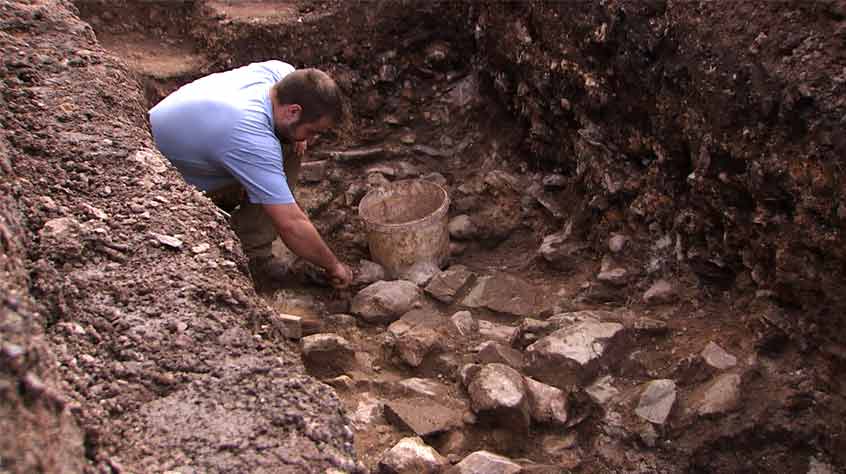 Archaeologist Tom Hoyle removes medieval rubble from Trench 1.