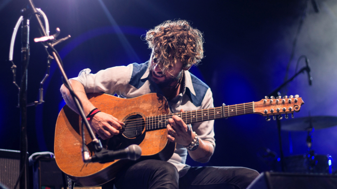 Man playing an acoustic guitar on stage