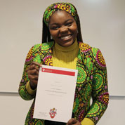 Regina Deri holding her graduation certificate.