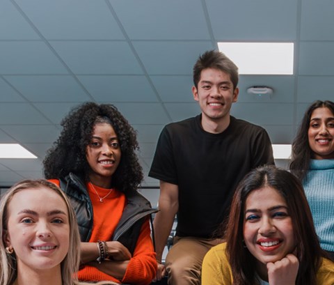students sitting in a lab, posing for the camera