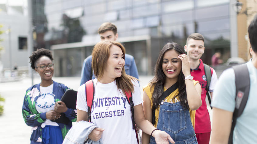 group of students walking and laughing on campus david wilson library in the background