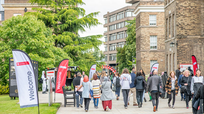 Lots of people walking through University of Leicester campus on an open day