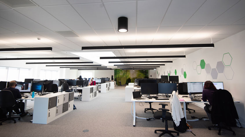 An open plan office with lots of computer terminals.