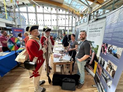 Outreach staff at event with men dressed in Red Coat costumes