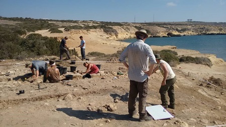 Archaeology students excavating a coastal dig site