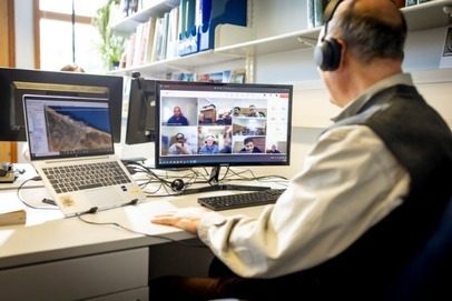 Person sitting in front of a computer screen making a video call