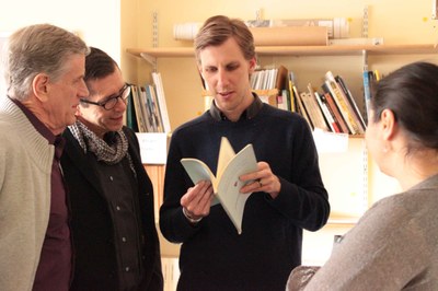 Delegates gathered round a man reading from a book