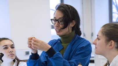 Member of staff teaching students in a science lab