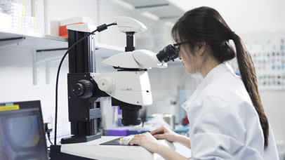 Student looking through a microscope in a science lab