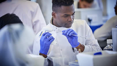 Postgraduate student using a pipette