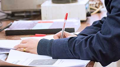 student writing on paper at desk