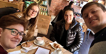 Four members of the Hodgkinson group enjoying coffee in a cafe with new PhD student Aline