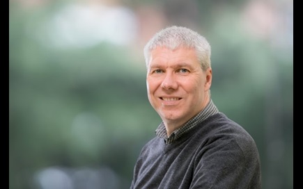 Photograph showing the head and shoulders of Professor Andrew Abbott in front of a blurred green background