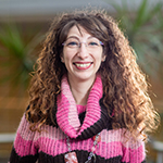 Photograph of Luisa Ciano, wearing a colourful pink striped jumper.