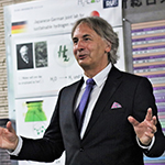 Photograph of Thomas Happe delivering a speech, gesturing with his arms.