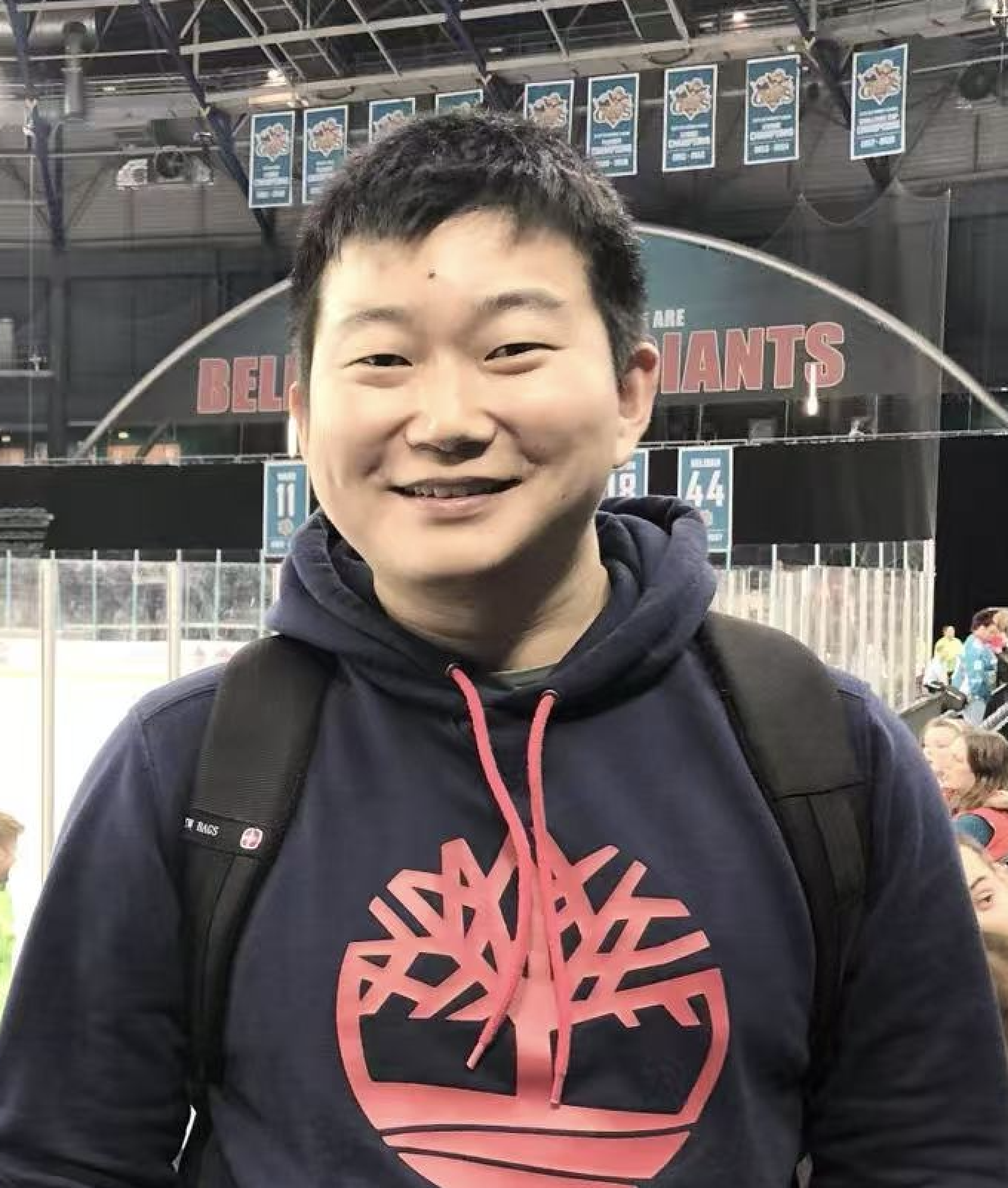 Photograph of Qun Cao. A young Chinese man, wearing a dark blue hoodie.