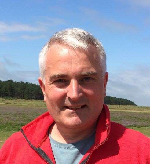 Photograph of Stephen Ball. A white middle-aged man wearing a red jacket.