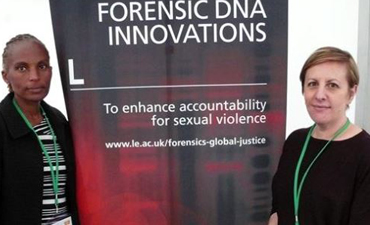 Two people stood next to a Forensic DNA innovations poster