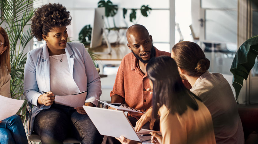Young businessman talking in a meeting with co-workers at work