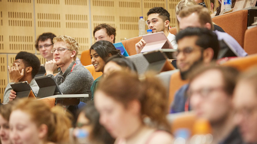 Students sitting in a lecture theatre.