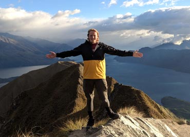 sam standing on top of mountain in new zealand