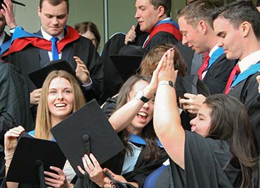 our students celebrating with a high five at graduation