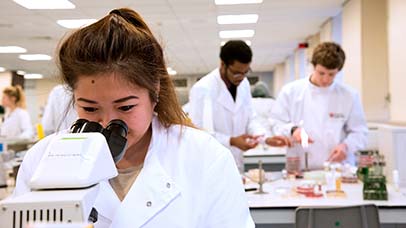 student using a microscope
