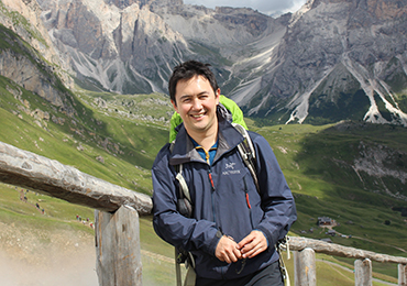 Alex Lui walking in front of mountains