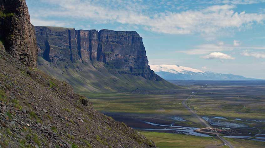 700 m-high cliffs cut by marine erosion in volcanic rocks erupted from volcanic fissures under ice on Iceland’s south coast; Öraefajokull in the background.