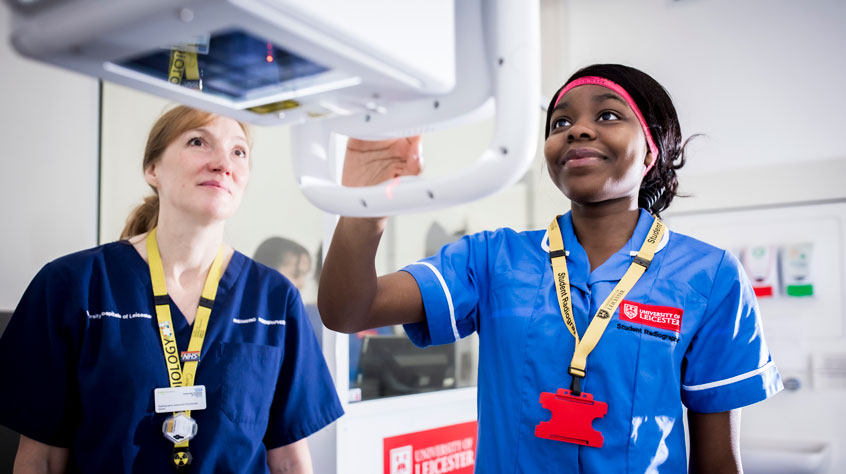 Student using an x-ray with a lecturer behind her
