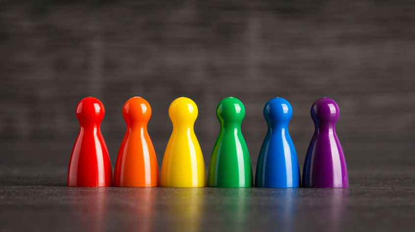 Rainbow coloured pawns lined up in a row