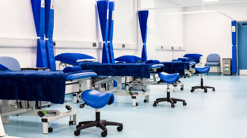 A row of beds in a physiotherapy clinic.