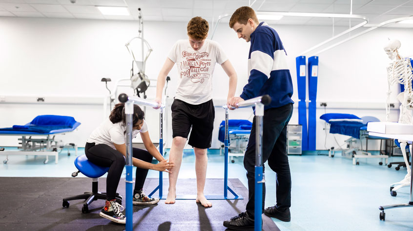 Physiotherapist showing a student how to use equipment in the clinic.