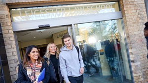Three students walking out of 'Leicester Law School'