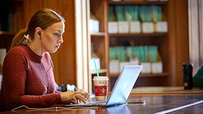 student using laptop in law library