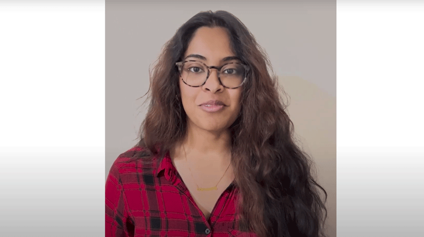 Sethara, a student with long brown hair and a red checked shirt