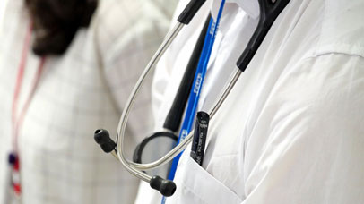 Close up of a doctor's coat with a pen in the pocket and the stethoscope in frame