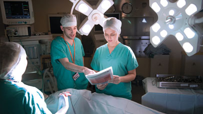 Two students in scrubs in an operating theatre