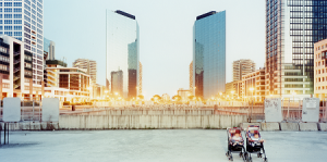 Photograph of a city landscape featuring symmetrical skyscrapers and bright street lighting horizontally through the centre of the image