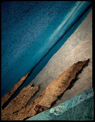 Photographic artwork based on coastal seascape featuring jagged rocks, deep and dark colour contrast between ocean, beach, rocks and stone wall