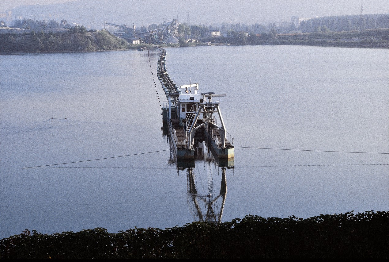 Photograph of a lake intersected by a structure trailed by pipes