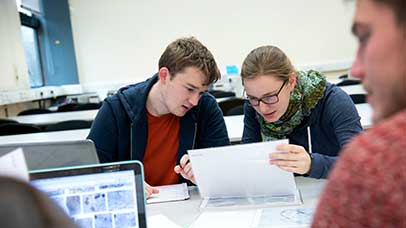 two students working on a tablet pc in class