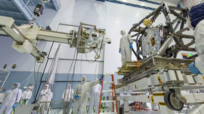 MIRI being lifted into position prior to integration to the JWST ISIM. MIRI, in its support frame, is at centre of picture; ISIM is towards the right. 29th April 2013 at NASA's Goddard Space Flight Center, Maryland USA. [Image courtesy of NASA.]