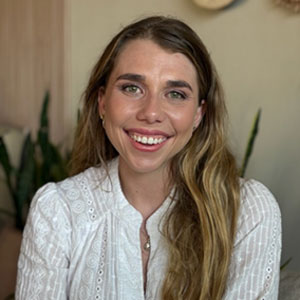 Woman wearing a white shirt and smiling at the camera.