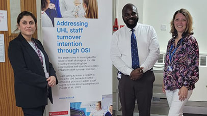 Members of research team standing by a research banner