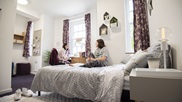 Two students chatting in a bedroom in student accommodation