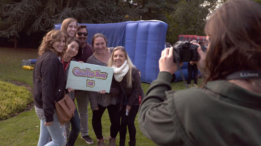 six students having their photo taken holding a banner at oadby fest