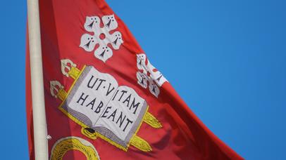 University flag with latin saying on it.