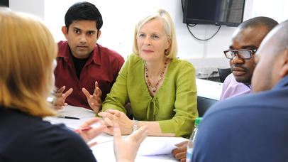 People sat round a table having a discussion.